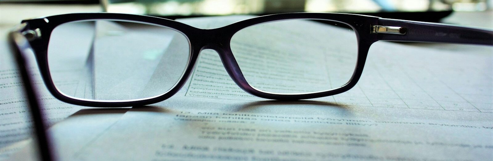 black-framed eyeglasses on white printing paper